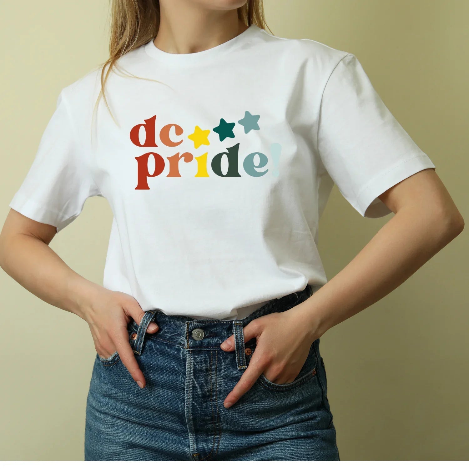 Woman wearing a white dc pride t-shirt with colorful stars, sustainable kids clothing by Jackalo