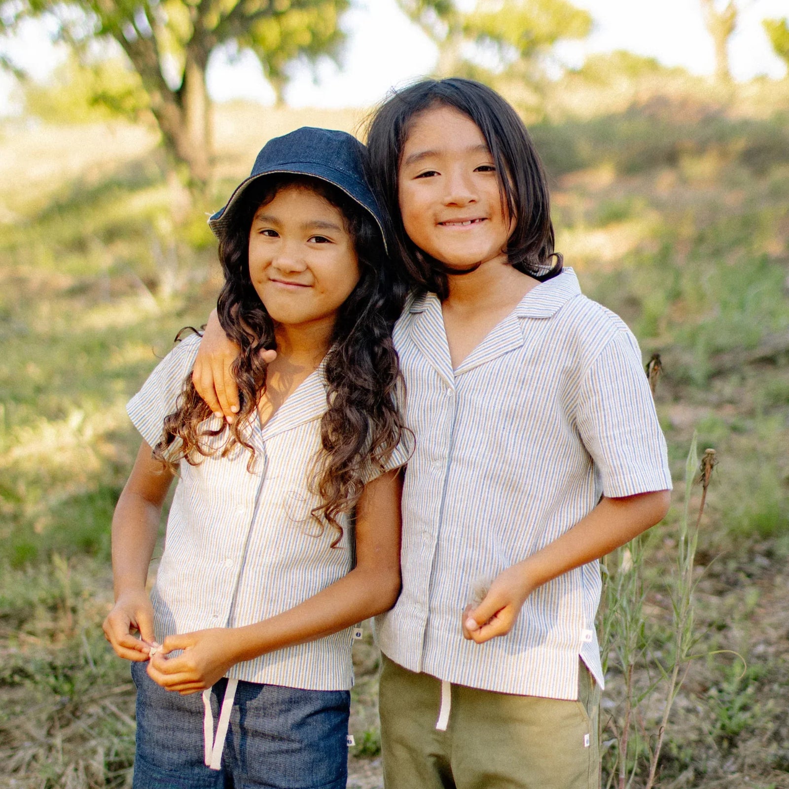 Two kids wearing Jackalo camp shirts outdoors, comfortable sustainable children's clothing