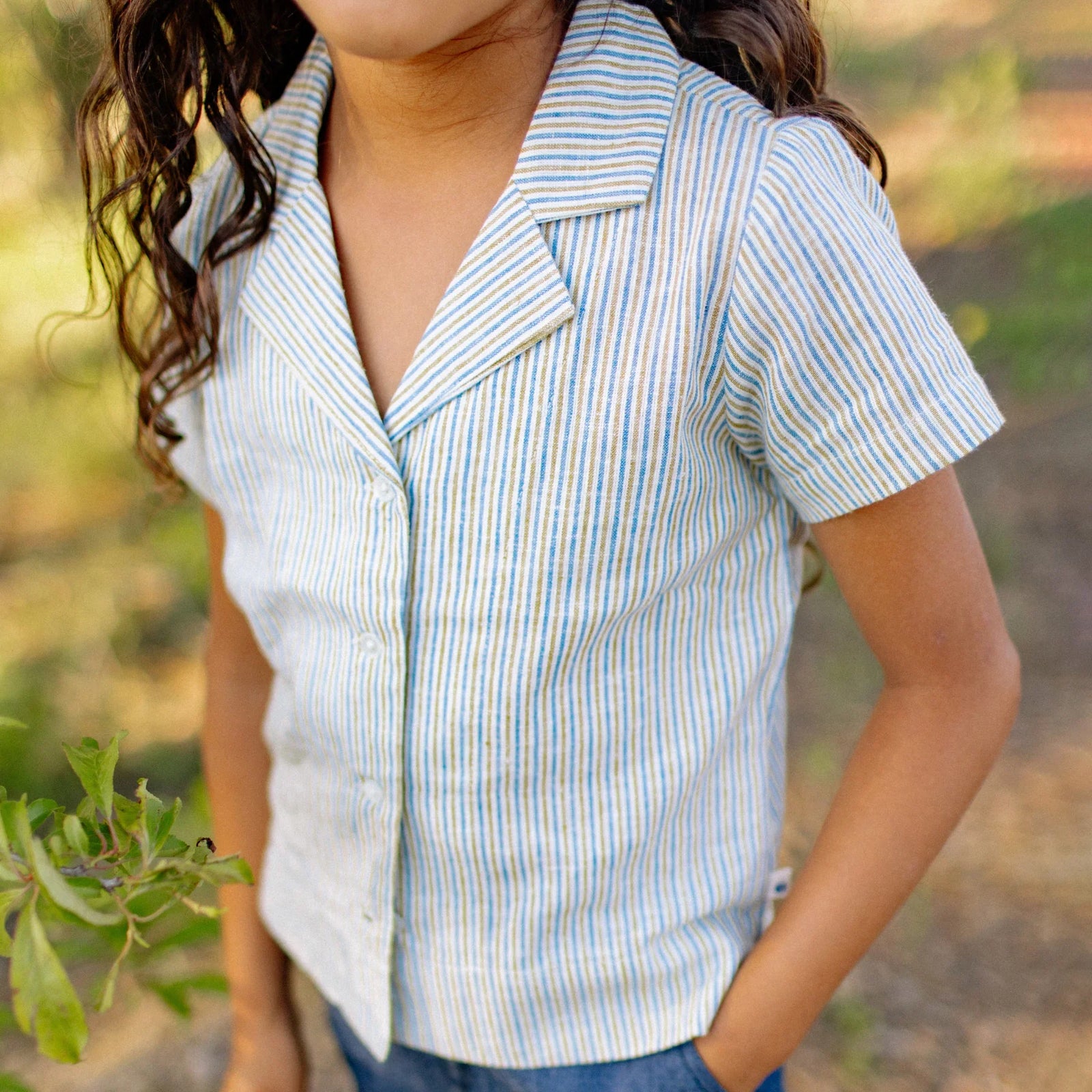 Child wearing Jackalo striped short sleeve camp shirt outdoors, sustainable kids clothing
