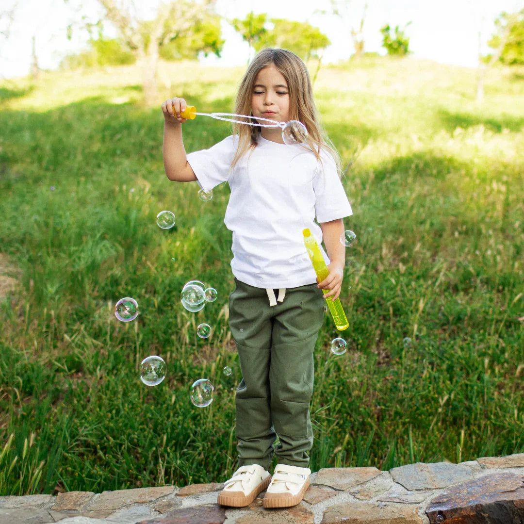 Child in organic cotton faded olive pants with reinforced knees from Jackalo