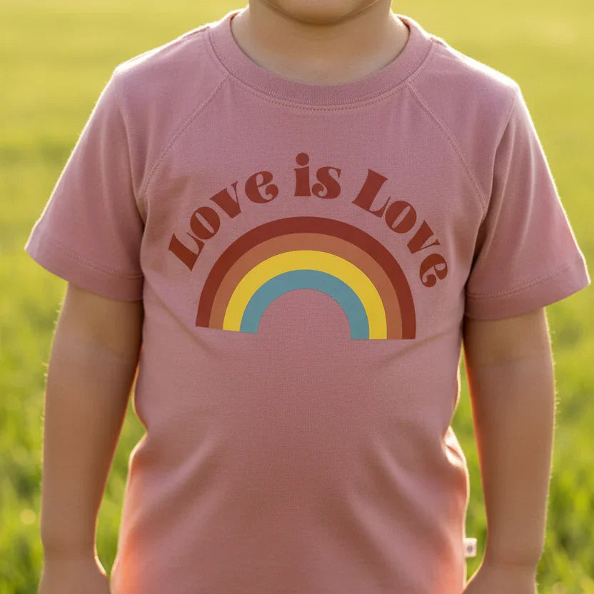 Child wearing sustainable pink 'Love is Love' rainbow t-shirt by Jackalo outdoors