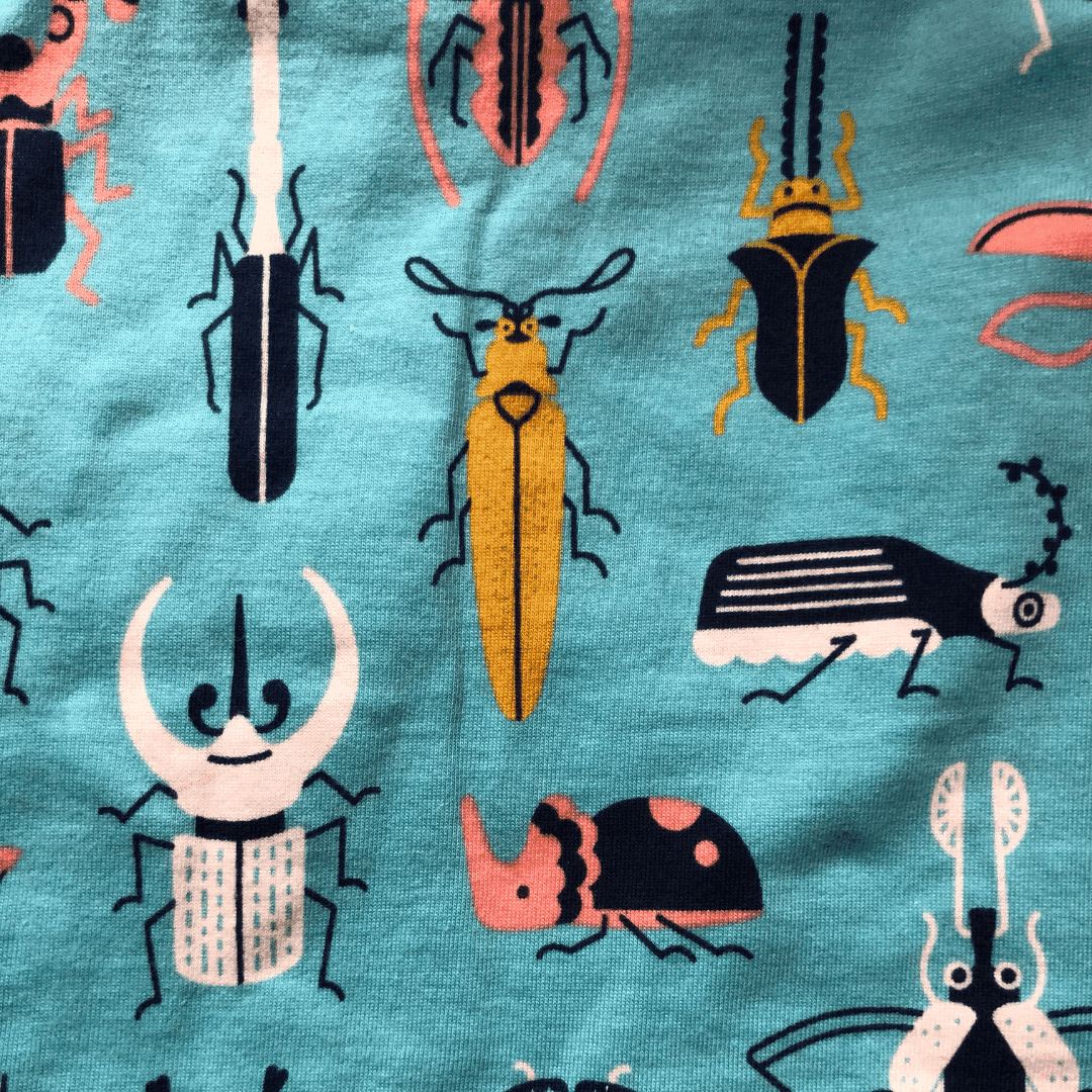 Jackalo kids shorts fabric featuring colorful beetle and insect print on teal background
