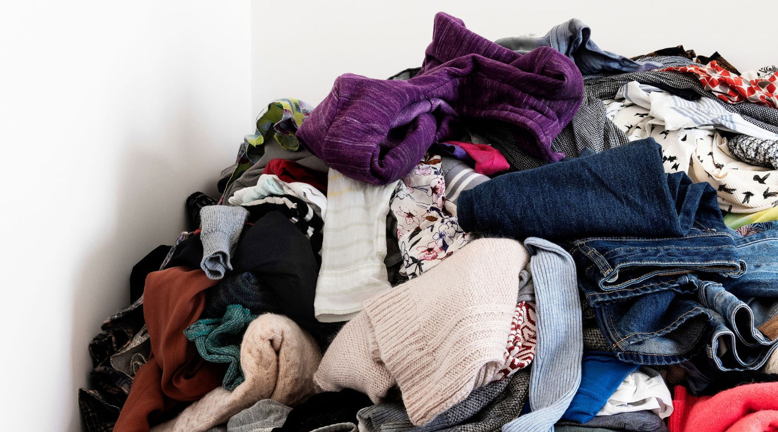 Pile of assorted colorful kids' clothes, denim, sweaters, and tops, Jackalo sustainable fashion