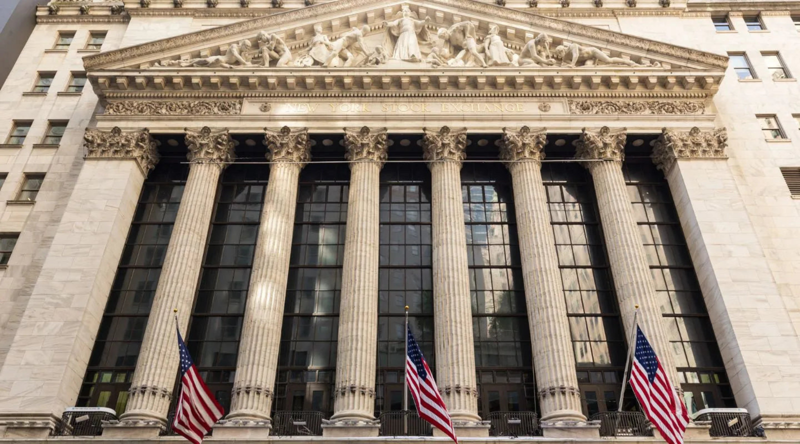 Front of New York Stock Exchange building with American flags and columns