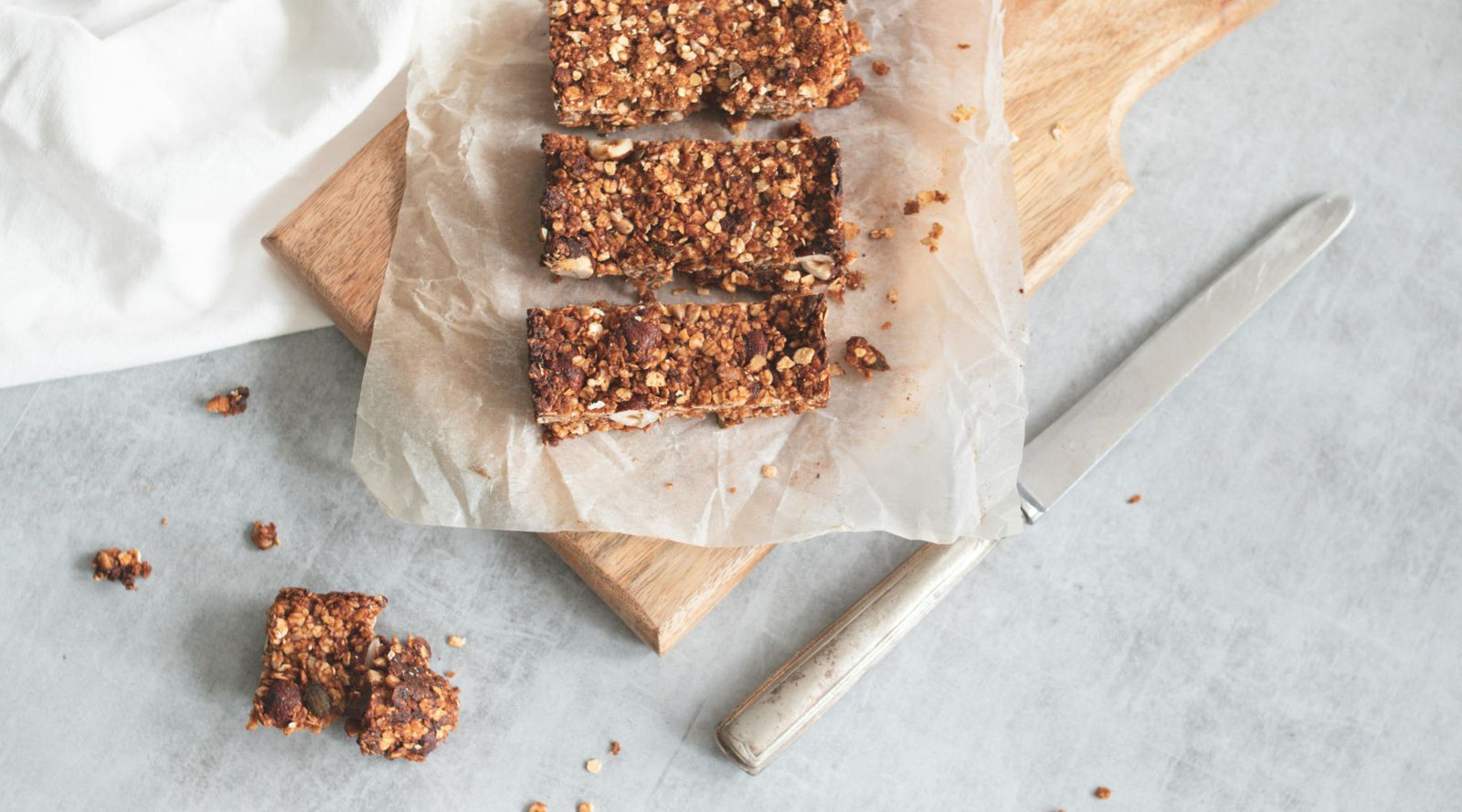 Homemade granola bars on parchment over a wooden board, healthy snack by Jackalo