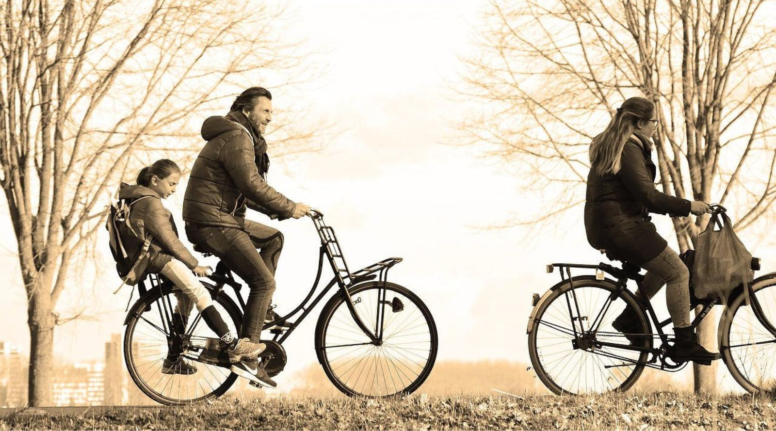 three people happily biking in a scenic park