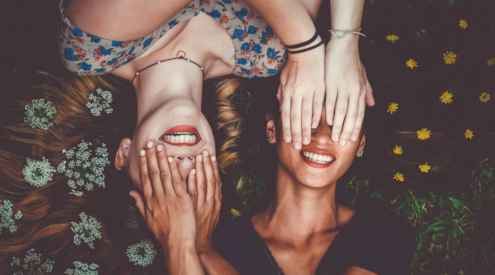 two women laughing covering their eyes