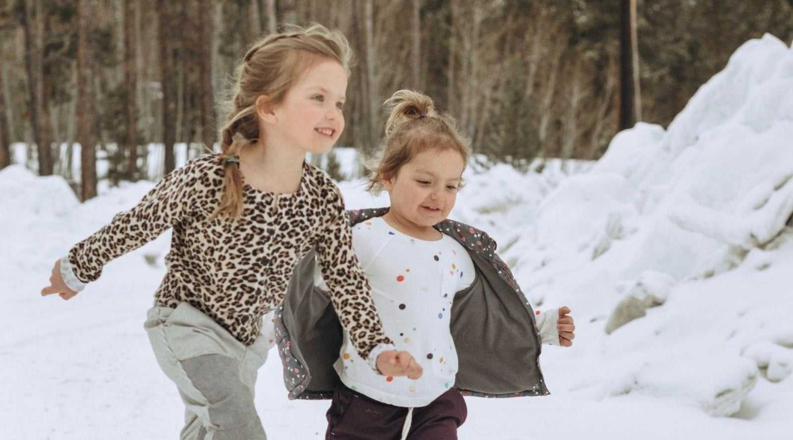 two young girls dashing through the snow