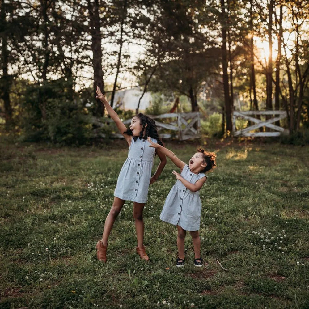 Sisters with matching pinstriped dress dancing