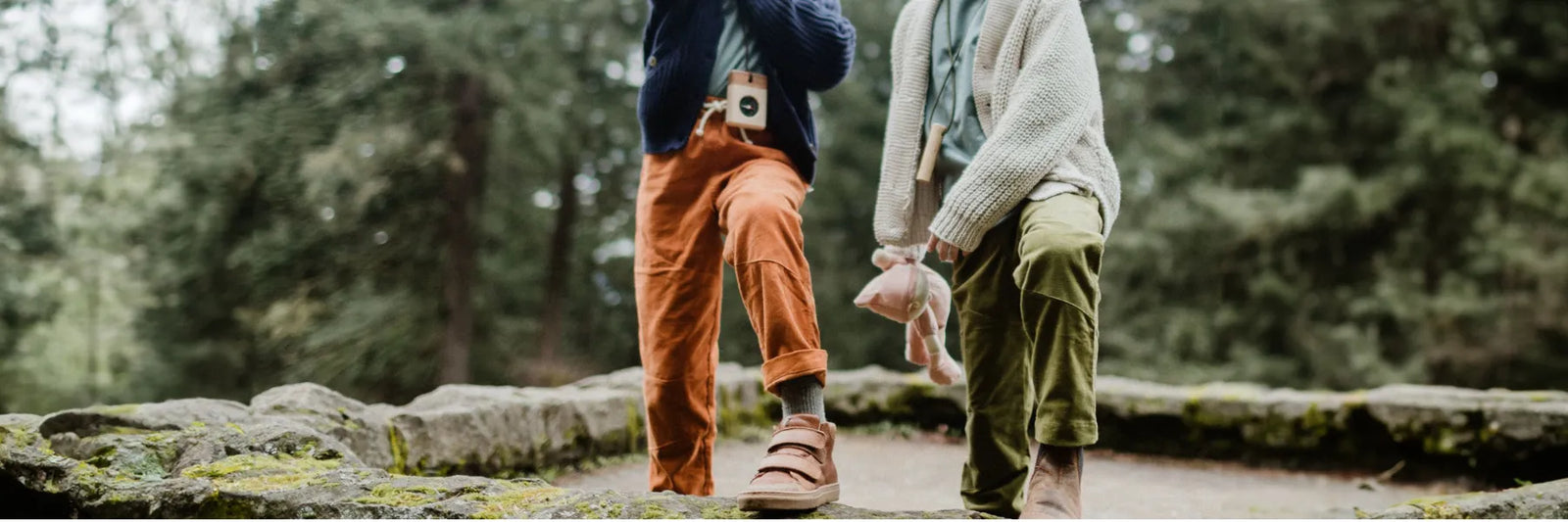 Two children playing outside, both wearing corduroy pants