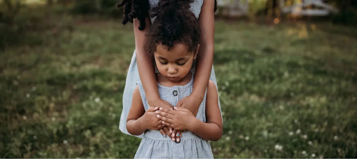 Little girl wearing a dress standing in a grassy field