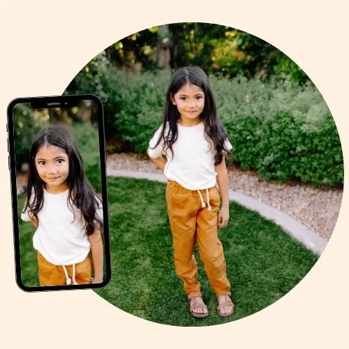 A little girl wearing white shirt and orange pants