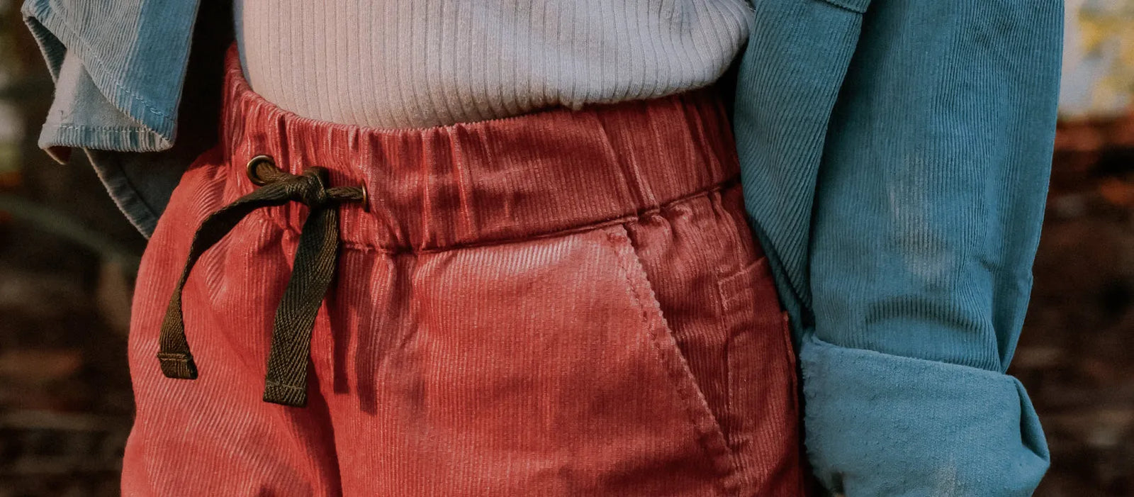 Cropped photo of a girl wearing jacket and red pants