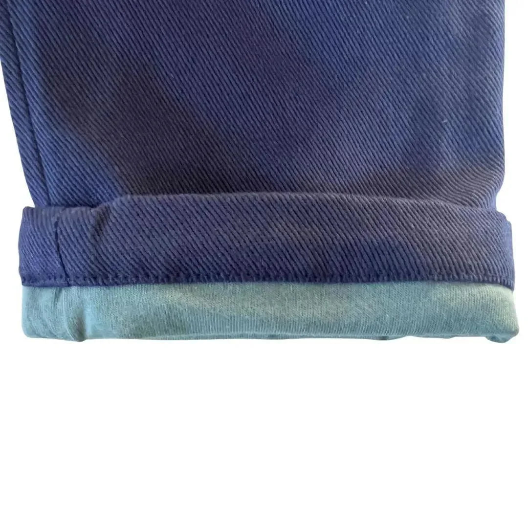 Close-up of a Jackalo kids rolled pant cuff in durable blue fabric, sustainable clothing