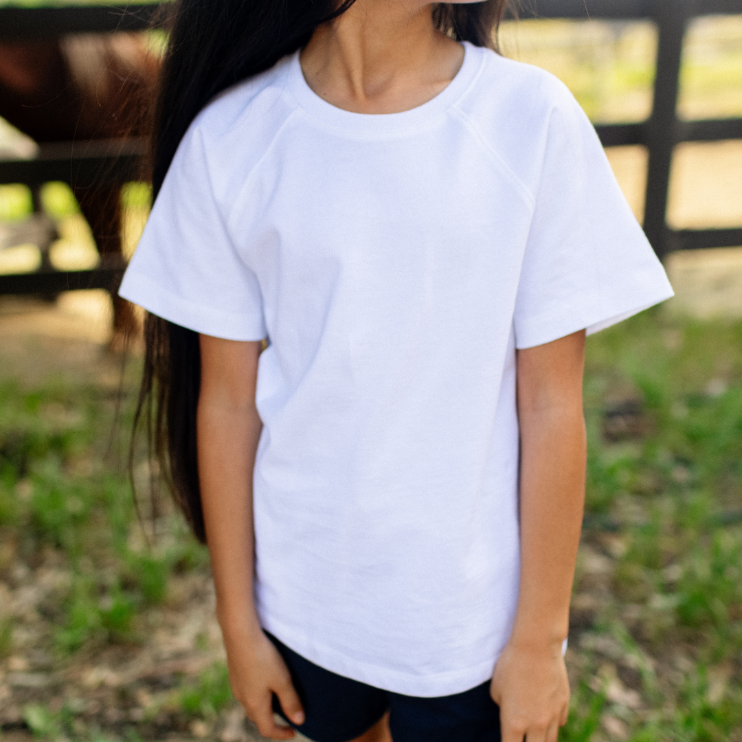 Child wearing an organic plain white t-shirt outdoors with a blurred background