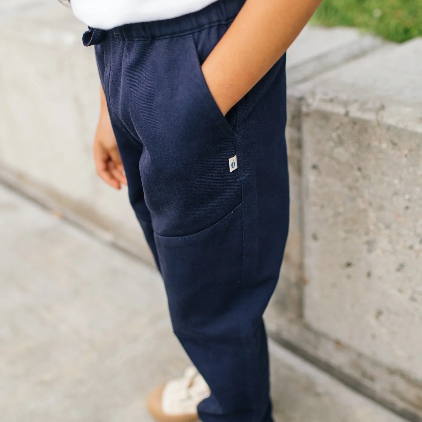 Child wearing Jackalo navy pants with pockets, sustainable kids clothing outdoors