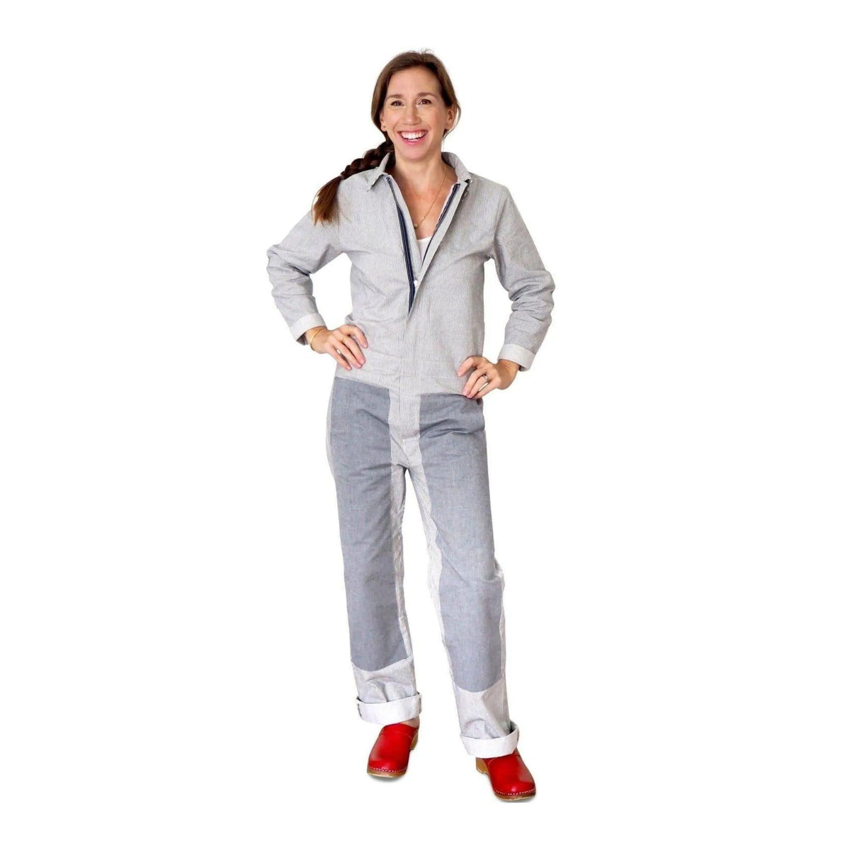 Woman in Jackalo sustainable coverall jumpsuit with red shoes, standing against white background