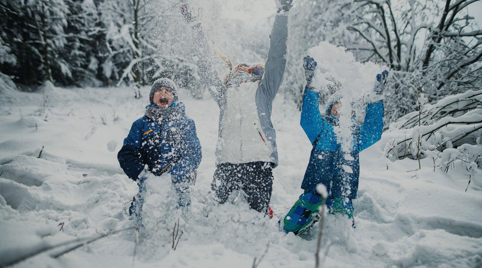 Three kids joyfully playing in the snow