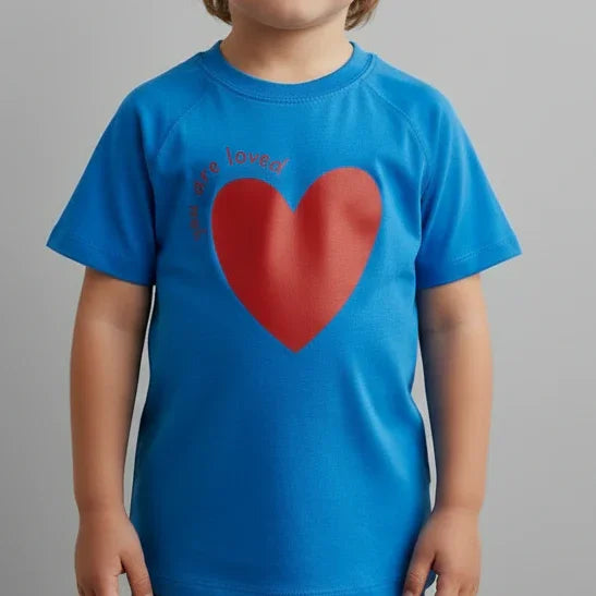 Child wearing Jackalo blue t-shirt with large red heart and 'you are loved' text for kids