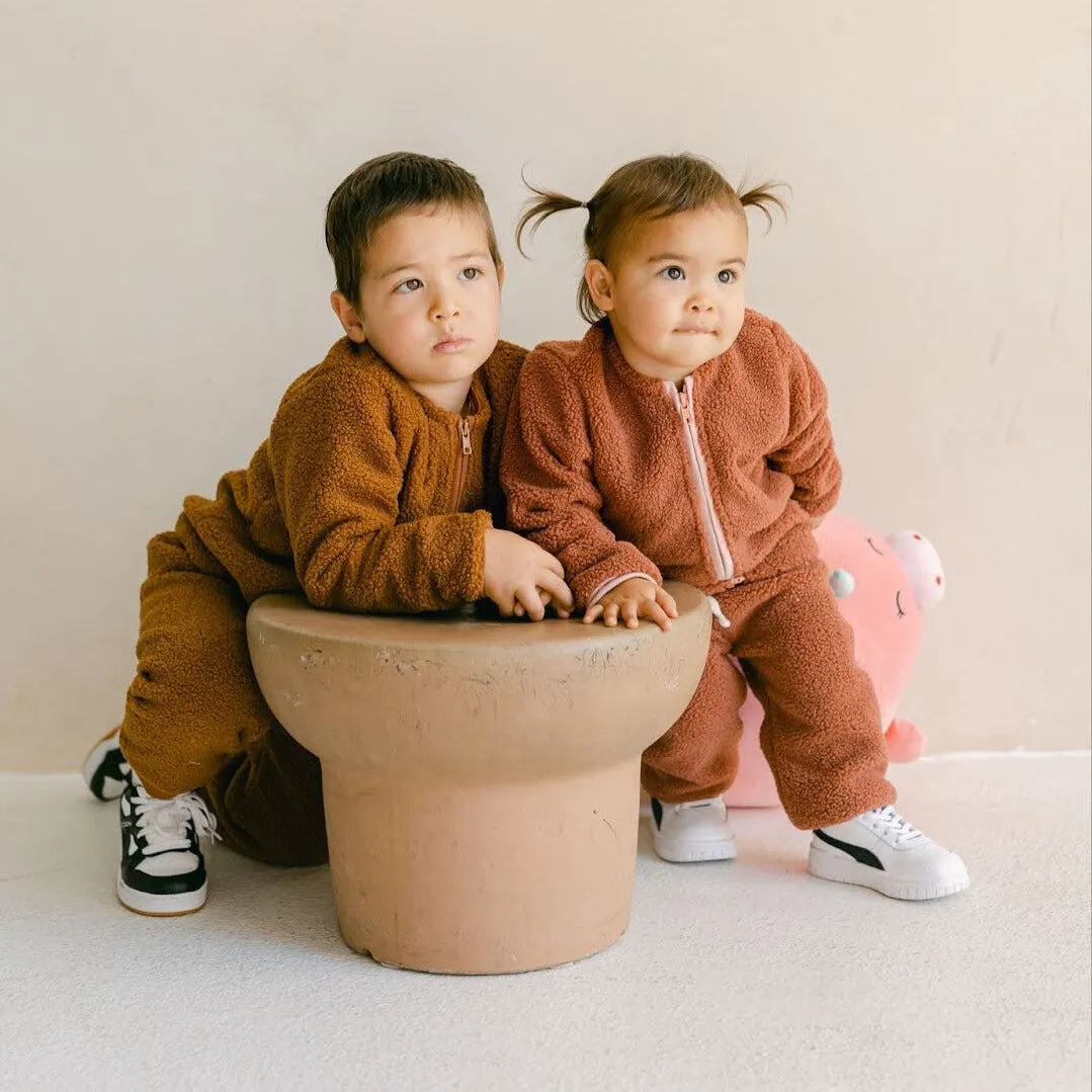 Two children wearing brown pajamas