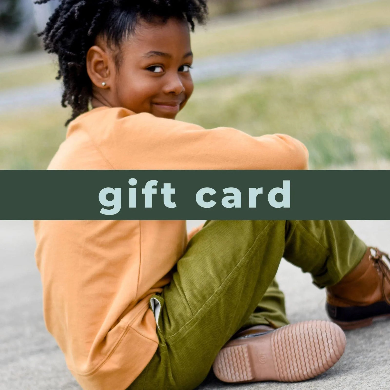 Gift card photo showing a young boy sitting on the ground