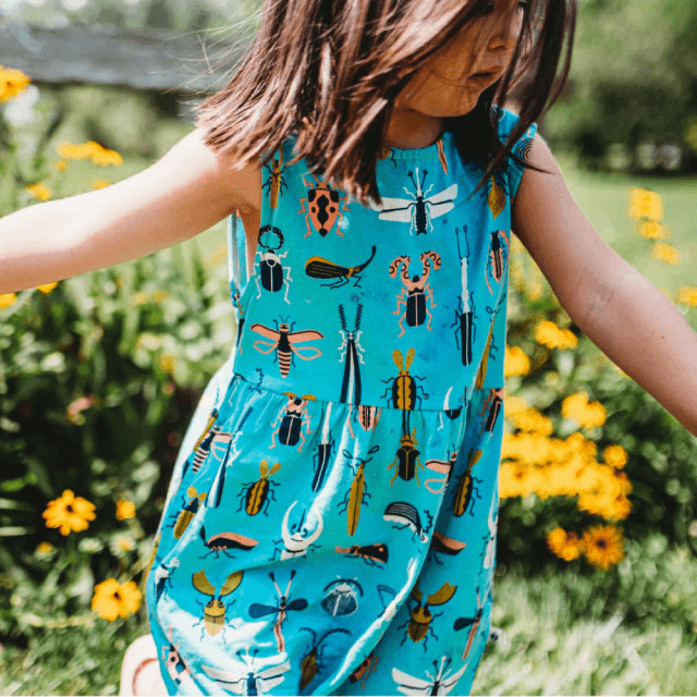 Girl in a field wearing a beetle printed dress