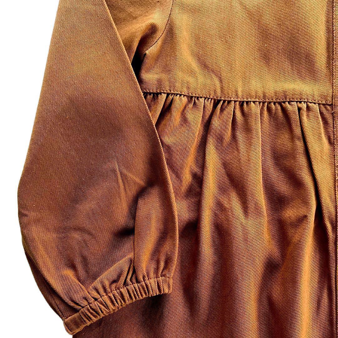 Close-up of Jackalo kids acorn brown long-sleeved sustainable dress fabric and sleeve