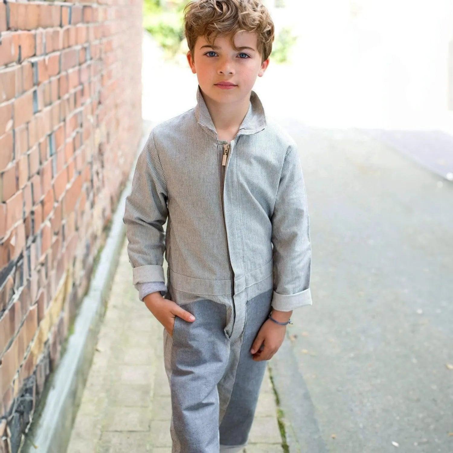 Boy wearing sustainable grey Jackalo coverall on street, long-lasting kids clothing